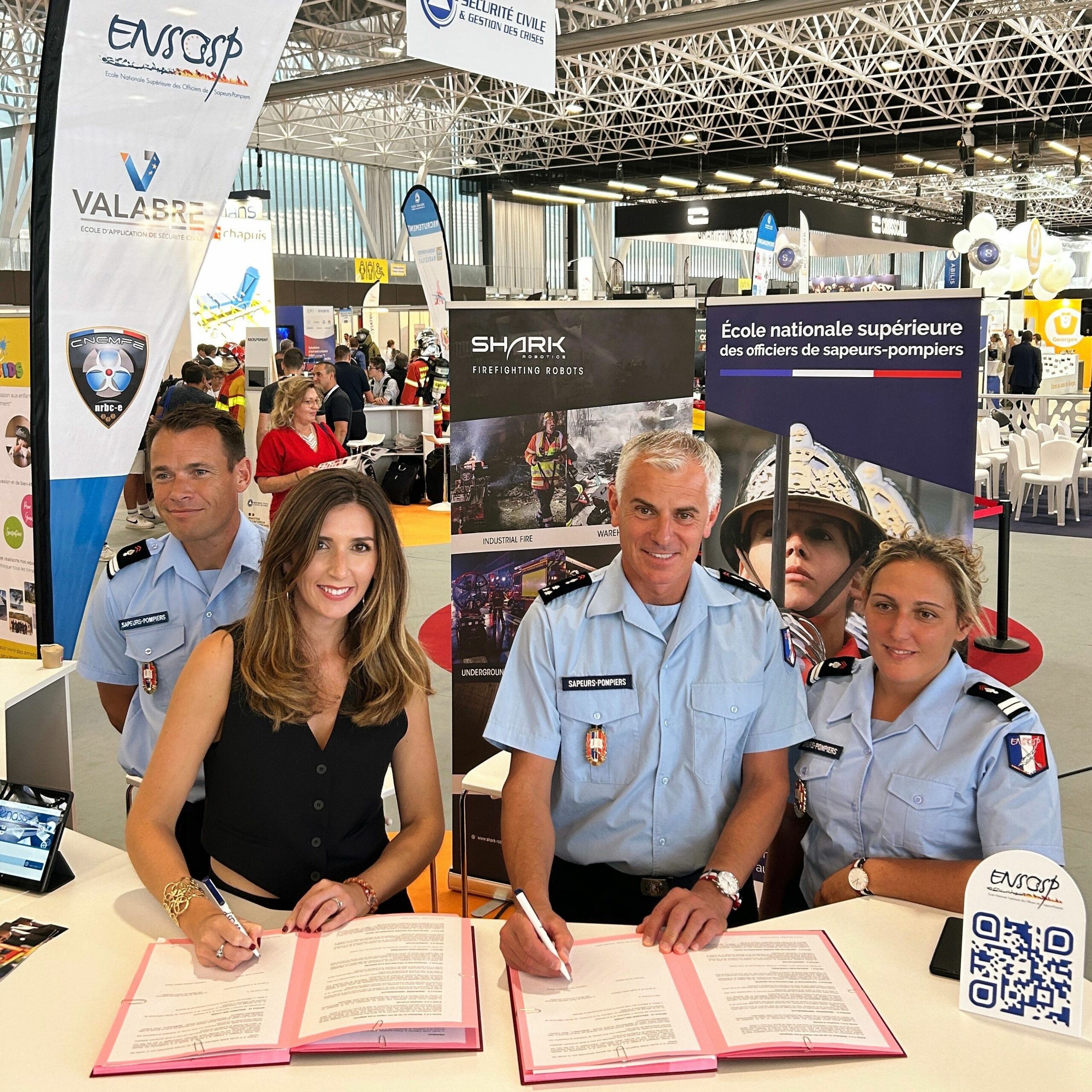 un groupe de personnes en uniforme signant des documents à une table