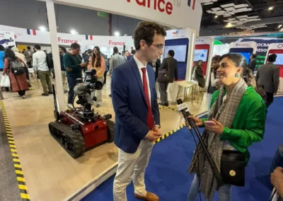 Bruno Cruchant answering an interview in front of French Pavillon at AI Expo in India with a female journalist and the Rhyno Protect behind